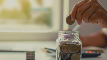 A coin goes into a glass jar. Saving money by Streamlining Process